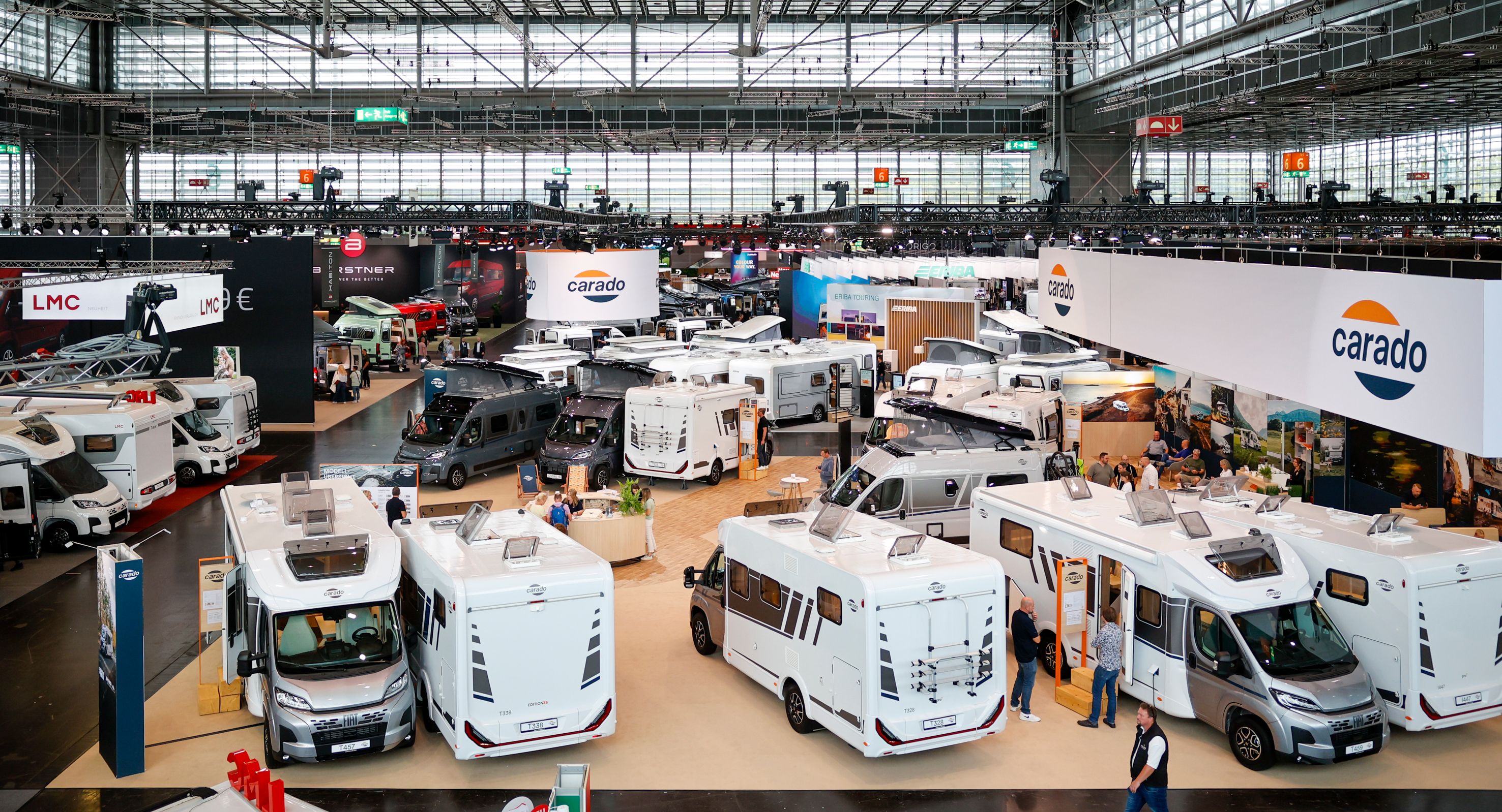 Blick über eine Messehalle mit Reisemobilen an den Ständen von Carado, LMC und Bürstner