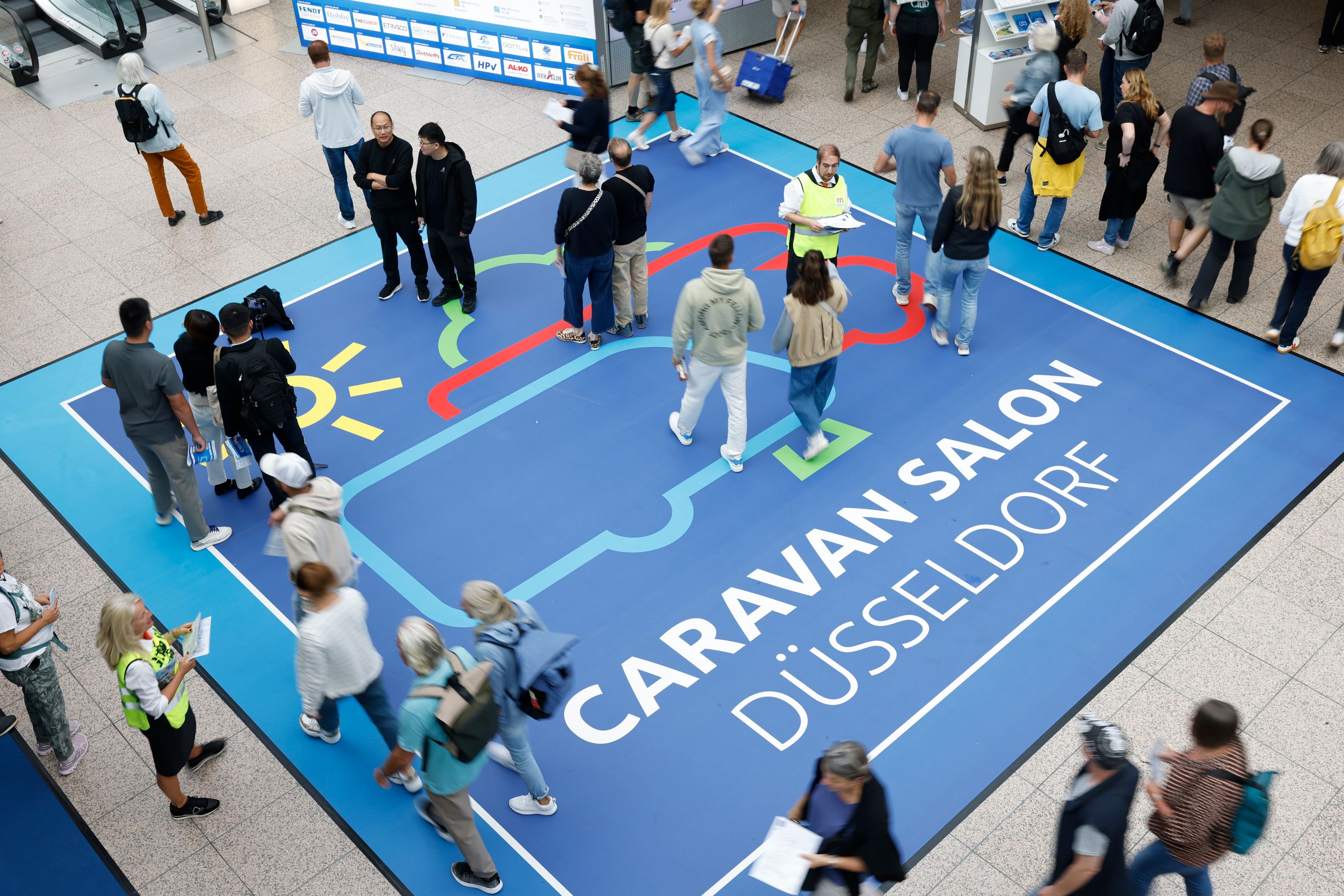 Bodengrafik mit dem Schriftzug Caravan Salon Düsseldorf im Eingangsbereich der Messe